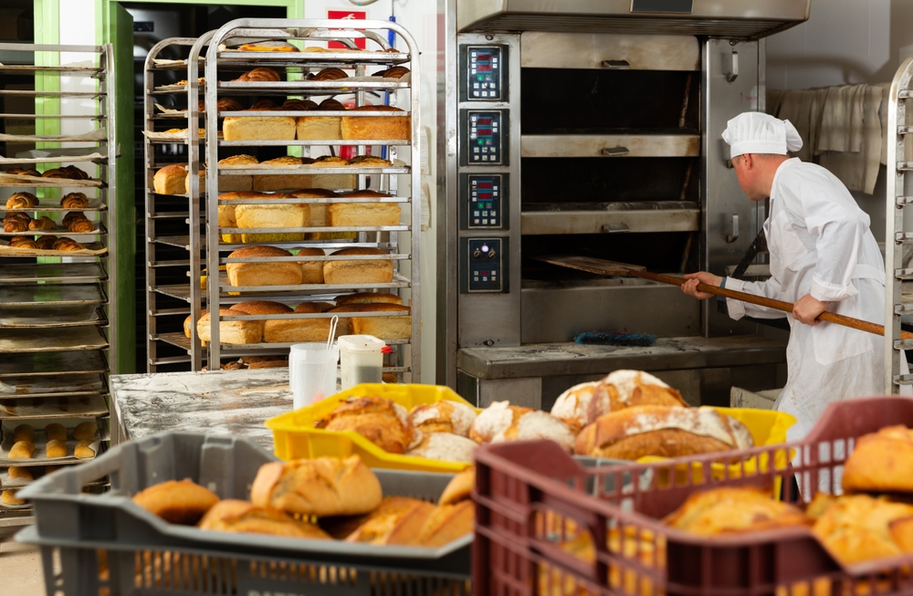 Baker putting bread in oven