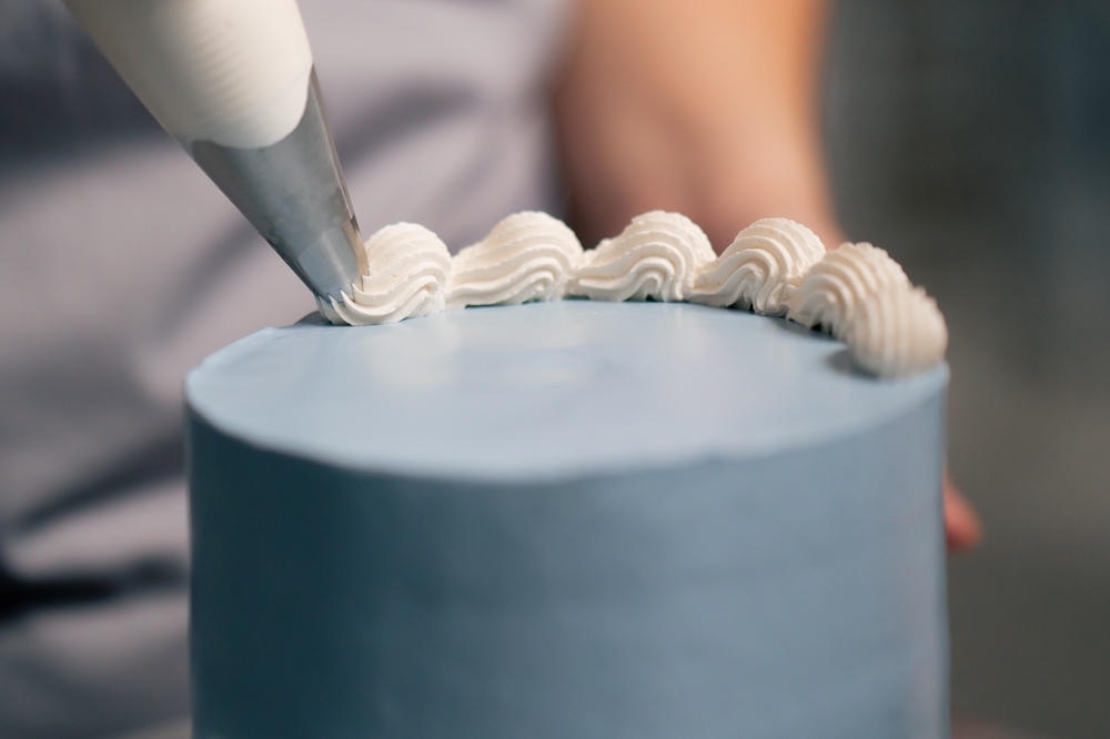 Close up of piping icing on a cake
