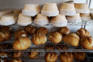 Fresh bread and proofing baskets on a bakery rack